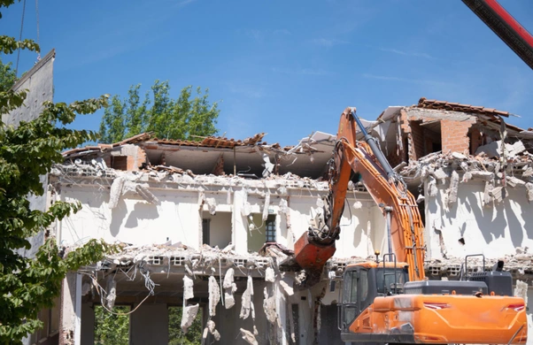 Excavator breaking concrete during Dallas demolition project by Best Dallas Demolition